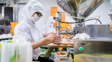Workers in a food processing factory packaging food